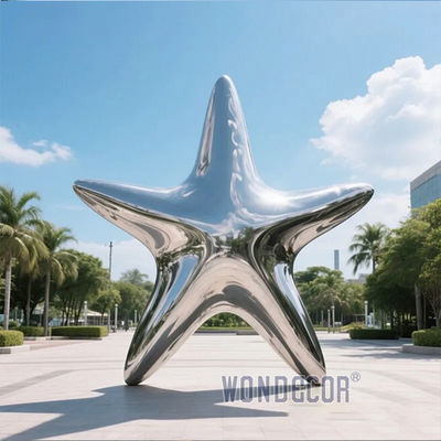Large stainless steel star shaped outdoor sculpture in the park